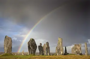 Mystery Prints: Standing Stones of Callanish bathed in sunlight with a rainbow arching across the sky in the background