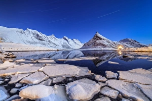 Starry Sky Prints: Star trails and lights on the snowy peaks reflected in the cold sea, Volanstinden