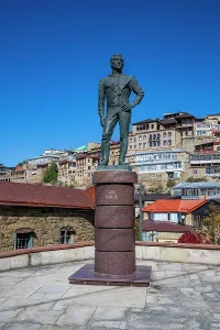 Identity Prints: Statue in the mountain village of Tschoch represents local history and culture with the village in the background