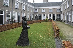 Lawn Prints: A statue of a nun stands in a courtyard of historic housing for women at the Begijnhof