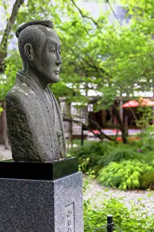 Residence Prints: Statue of a samurai in Kakunodate Historical Village with green trees and traditional architecture in the background