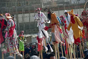 New Year Prints: Stilt dancers in parade at New Year celebrations in Qinghai Province, China, Asia