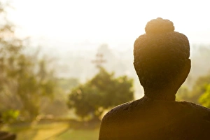 Borobodur Prints: Stone Buddha statue at sunrise at the Buddhist Temple