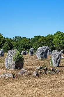 Stones Prints: Stone formations stand in open field under clear sky in rural France near trees