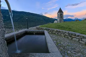 Stone fountain next to bell tower, Xenodochio of Santa Perpetua, Tirano, province of Sondrio