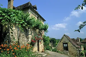 Charm Prints: Stone houses with climbing plants and flowers in Saint-Cirq-Lapopie in France during a sunny day