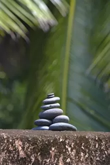 Stones balanced on rock, palm trees in background, Maldives, Indian Ocean, Asia