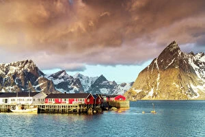 Nordland County Gallery: Storm clouds at dawn over mountain peaks and fishing village of Sakrisoy, Reine, Nordland county