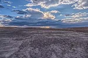 Wonders Prints: Storm clouds gather over the landscape near Petrified Forest National Park in Arizona while viewed from a gray plain