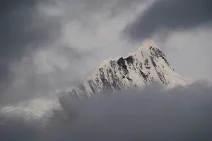 Altitude Prints: Storm clouds gather over snowy ridges of Kawagebo Peak in the Meili Mountains of Yunnan