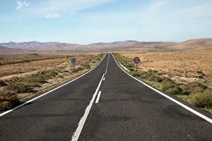 Paved Prints: Straight tarmac road crossing desert