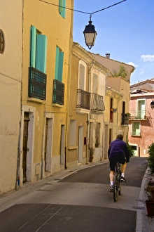 Cyclist Prints: Street with cyclist, Old town, Bouzigues, Thau basin, Herault, Languedoc, France, Europe