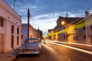 Cienfuegos Prints: Street scene at night showing Classic American car and the light trails of passing traffic