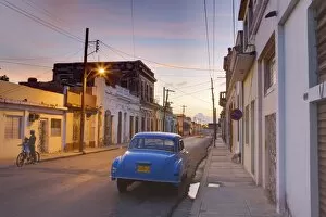 Images Dated 28th March 2009: Street scene at twilight with classic blue American car, Cienfuegos, Cuba