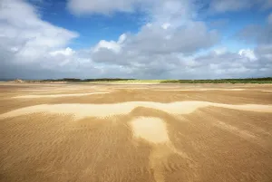 Eroded Prints: Strong wind shapes sand patterns across Whiteford Sands in Swansea, Wales
