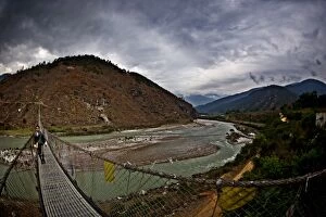 Images Dated 22nd May 2009: A student crosses Bhutans longest suspension bridge, Panakha, Bhutan