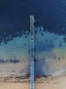 Voyages Prints: A stunning aerial image shows a solitary pier extending into the vast