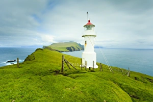 Stunning coastal scenery and the Mykinesholmur lighthouse, a footbridge connects this islet with the island of Mykines over a 35 metre deep gorge, Mykines Island, Faroe Islands