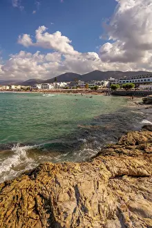 Hotels Prints: Stunning view of Akti Navarchou Nearchou Beach in Limenas Chersonisou with rocks and people enjoying the sun in Greece