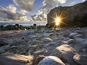 Quiberon Prints: Sun burst aligned with the natural arch of Port Blanc, Quiberon, Brittany, France, Europe