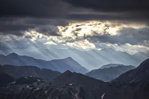 Valtellina Prints: Sun rays filter between black clouds at sunset