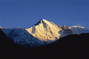 Sun on snow-capped high mountain peaks