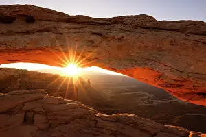 Natural Arch Prints: Sunlight envelops the Canyonlands Valley during a summer sunrise