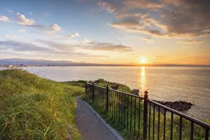 Fence Prints: Sunrise over Cape Tachimachi with a pathway along the coast in Hakodate, Hokkaido, Japan