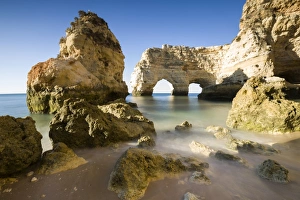 Sunrise on the cliffs and turquoise water of the ocean, Praia da Marinha, Caramujeira
