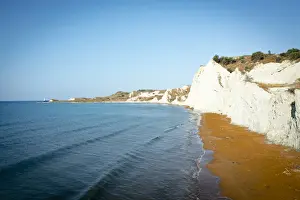 Sunrise over the gold sand of Xi beach surrounded by majestic limestone cliffs, Kefalonia, Ionian Islands, Greek Islands, Greece, Europe