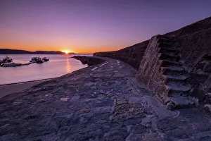 Lyme Regis Prints: Sunrise at the harbour wall known as The Cobb in Lyme Regis