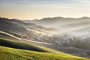 Sunrise light in the mist on gentle hills in the countryside, Emilia Romagna, Italy