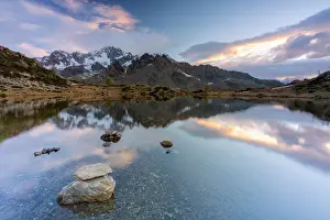 Lombardy Prints: Sunrise lit the rocky peak of Monte Disgrazia mirrored in the clear water of lake Zana
