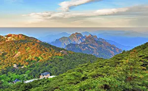 Breathtaking Prints: Sunrise over the mountains in Huangshan to show the landscape of Anhui Province in China with trees and distant peaks