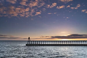 Silhouetted Gallery: Sunrise over the North Sea and Whitby harbour and piers in late summer, Whitby