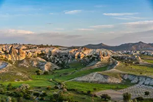 Love Prints: Sunrise over rock formations in Love valley near Cappadocia showing unique shapes and surrounding green land