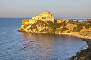 Sunrise on turquoise sea frames the medieval Falconara Castle, Butera, Province of Caltanissetta