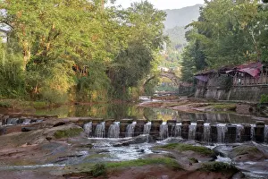 Sichuan Prints: Sunrise view of ancient arch stone bridge in Shangli Town with waterfall flowing in the river