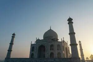 Mughal Prints: Sunrise view of Taj Mahal from a distance with towers visible in the early morning light in Agra