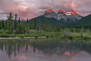 Flowing Water Prints: Sunset and Alpenglow on the peaks of Three Sisters, Canmore, Alberta, Canadian Rockies