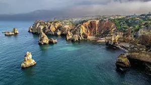 Azure Prints: Sunset over beach cliffs near Lagos featuring rock formations and coastline in Algarve