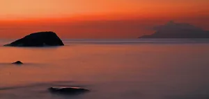 Retreat Prints: Sunset over Beau Vallon beach with rock formations and distant land in the Seychelles