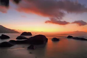 Purple Prints: Sunset at Beau Vallon beach with rocks and soft waves in Seychelles