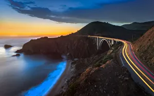 Sunset over Bixby Creek Bridge and car trail lights, Big Sur, California, United States of America