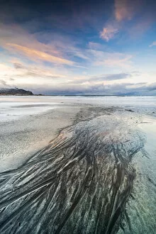 Nordland County Gallery: Sunset over the black sand of Skagsanden beach covered with ice in winter, Flakstad
