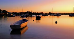 Watercraft Prints: Sunset over calm waters with boats at Grand Baie