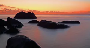 Retreat Prints: Sunset over calm waters with large rocks at Beau Vallon beach in Seychelles