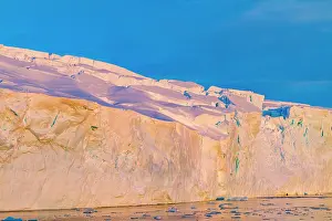 Bright Prints: Sunset glow on icy cliffs near Stonington Island in Antarctica's Southern Ocean during late afternoon