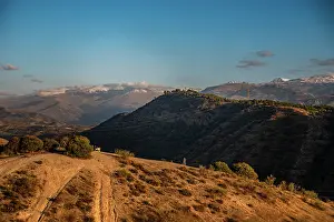 Granada Prints: Sunset over the hills behind Granada and wide landscapes with the snowy Sierra Nevada behind