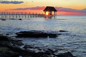Paradise Prints: Sunset illuminates the pier at Pointe aux Piments in Mauritius with ocean waves lapping shore